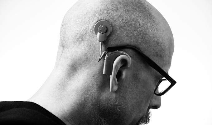 Man with a cochlear implant and hearing aid